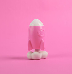 Toy space shuttle or rocket on pink background. Minimalism, conceptual pop, fresh idea or startup