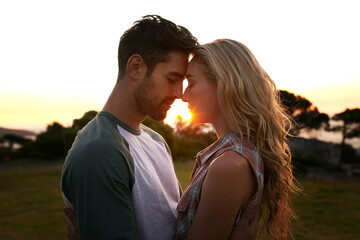 Sunset, love or couple in nature on romantic holiday vacation for bonding or relaxing on date together. Forehead, travel or people hug or embrace in summer with romance or peace in park in the dark