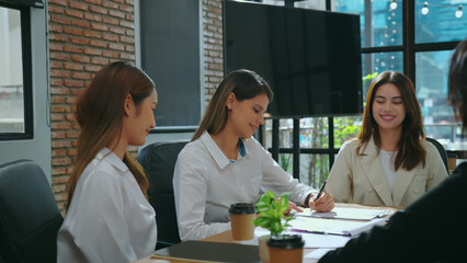 Young businesswoman enthusiastically shook hands with her team, having come to an agreement on the conditions of the business plan or project and feeling excited about the possibilities ahead.