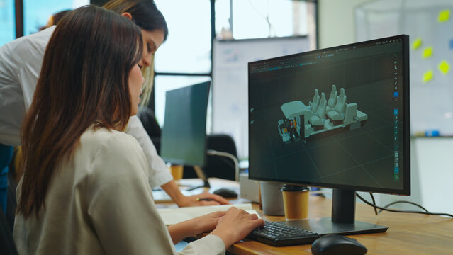 Female designer using computer to design ev car prototype at office. She used a 3D model to create a car model.