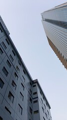 Bottom view of modern skyscrapers high buildings in Jakarta business district against afternoon. Looking up at business buildings in downtown