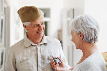 Military, medal and honor with a senior couple in their home, feeling nostalgic about army service. War hero, award or memory and a mature man soldier in a house with his wife, feeling patriotic