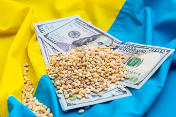 Wheat grains with dollar bills on Ukrainian flag. Export cereals from Ukraine.