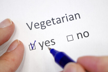 Questionnaire. Pen and the inscription VEGETARIAN with check mark on the white paper