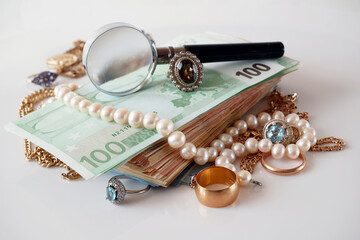 many golden and silver jewelry, pearls and money on white background, pawnshop concept, jewelry shop concept, closeup
