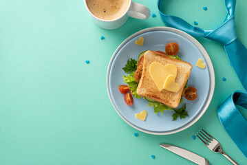 Celebrate Father's Day with a surprise breakfast for Dad. Top view of sandwich with heart-shaped cheese, cutlery, coffee mug, necktie, sprinkles on a teal background with space for text or advertising