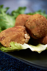 Breaded potato nuget, with orejona lettuce, with dry chile sauce, a coffee in the background
