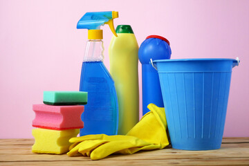 plastic bucket with brushes, gloves and detergents in the kitchen, basket with cleaning items