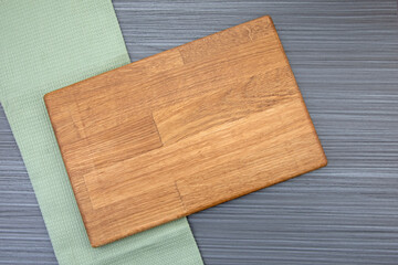 Green tea towel and wooden board, copy space