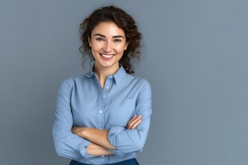 Happy young smiling confident professional business woman wearing blue shirt, pretty stylish female executive looking at camera, standing arms crossed isolated at gray background, Generative AI