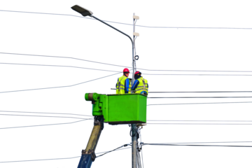 Electrical engineers repair the line standing on the crane platform at a high pole, isolated on a white background
