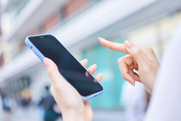 街角でスマートフォンを使う女性の手元