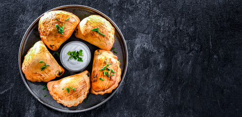 Composition with a plate of oven-baked pierogi