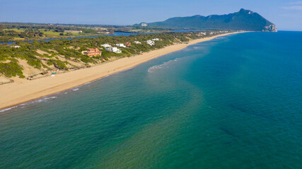 Aerial view of the seafront of Sabaudia, Italy. The beach is almost empty. In the background the...