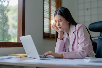 Portrait of business owner, woman using computer and financial statements Anxious expression on expanding the market to increase the ability to invest in business