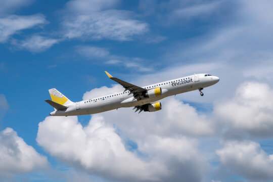 Vueling Airbus A321 airplane in flight against a blue cloudy sky taking off from the airport 