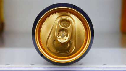 Close-up of the top of a metal golden can lying on its side