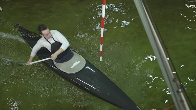 caucasian man rowing a black kayak. training in the pool. slow motion video. view from above. High quality Full HD video recording