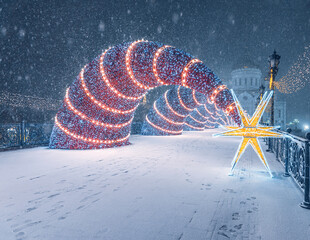 The "Shooting Star" decoration near the Cathedral of Christ the Savior. New Year's Moscow. Snowfall in the city. Patriarch's Bridge in winter.