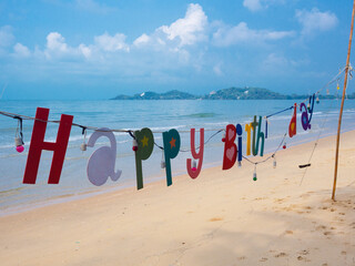 Birthday decorations on the sandy beach by the ocean.