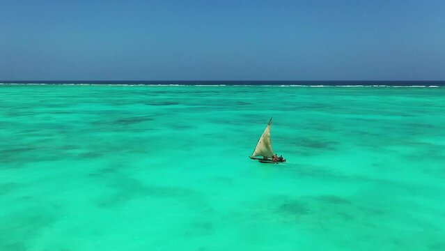 Sailboat in the ocean. Drone Shot of Sail Boat Traveling in Calm Waters in Indian Ocean. Sun seascape with white sails yacht. Luxury yachting lifestyle at summer sunny day.