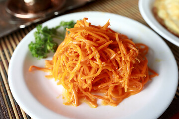 Korean spicy carrot salad on white plate
