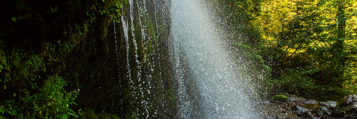 waterfall in a natural park, water stream falls from above,banner
