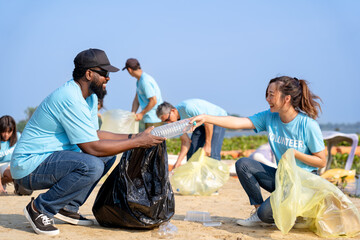 group of diverse volunteers charitable working together to clean up river beach, senior adult and...
