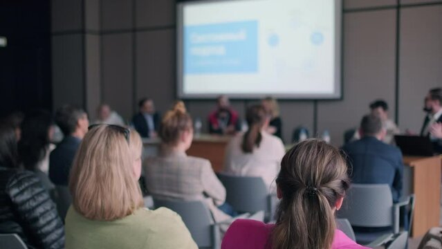 People attending symposium sitting in conference hall
