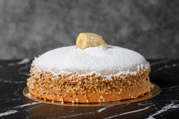 Banana and cream cake. German pie. Banana and cream cake on a dark background.