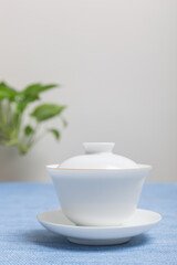 White ceramic teacup in Jingdezhen, China, on wooden table, indoor dark background,traditional chinese tea set