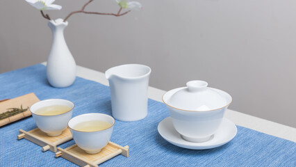 White ceramic teacup in Jingdezhen, China, on wooden table, indoor dark background,traditional chinese tea set