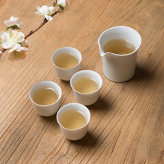 White ceramic teacup in Jingdezhen, China, on wooden table, indoor dark background,traditional chinese tea set