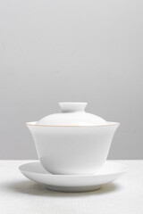 White ceramic teacup in Jingdezhen, China, on wooden table, indoor dark background,traditional chinese tea set