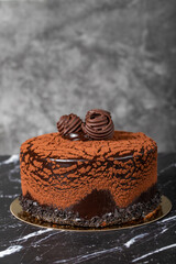 Chocolate cream cake. Birthday or celebration cake. Cake with cocoa and chocolate cream on a dark background.