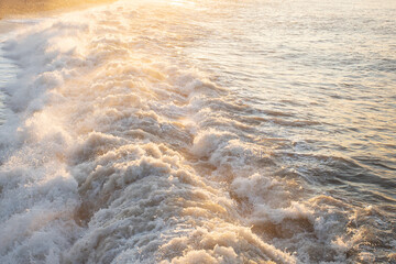 Splashing waves on the pebbly beach On the Sunset