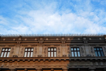 Top floor of historical building in neoclassical architecture style with row of architrave windows...