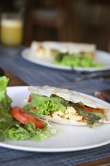 Tortilla wrap portion with green salad served on the restaurant table