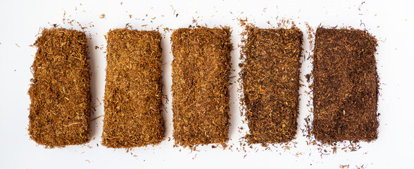 Different varieties of tobacco on a white background. Quality organic. Danish miscellaneous tobacco in the form of tiles finely chopped tobacco leaves for rolling cigarettes.