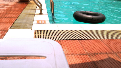 Handrail on the pool. Swimming pool with stairs and rubber tyer.  Water swimming pool with sun...
