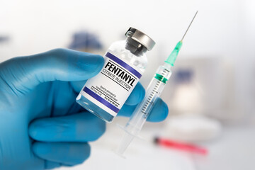 medical professional with vial and injection of dose of Fentanyl Citrate Solution for analgesic treatment. Doctor holding medical injection of medication of Fentanyl is opioid used to palliate pain or