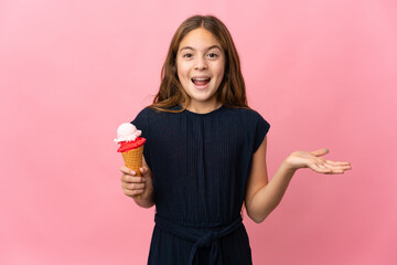Child with a cornet ice cream over isolated pink background with shocked facial expression
