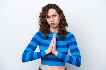 Young caucasian woman isolated on white background keeps palm together. Person asks for something