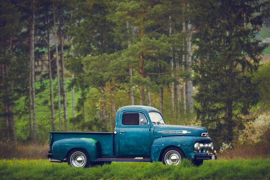 Classic oldtimer vintage American pick-up truck of the 1950s on a country road