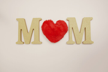 Mom alphabet letter and red heart flat lay on pink background