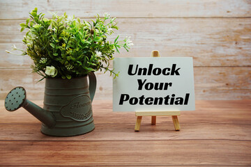 Unlock Your Potential text message write on paper card standing with easel  on wooden background