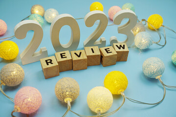 Review 2023 letters with LED cotton balls decoration on blue background