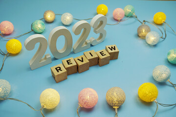 Review 2023 letters with LED cotton balls decoration on blue background