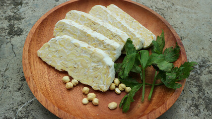 Tempe slices on a wooden plate. Tempeh or Tempe is an Indonesian specialty.
