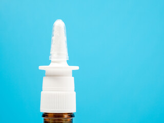 Nasal spray bottles on a blue background, treating a cold with a nasal spray. Medicine close-up.